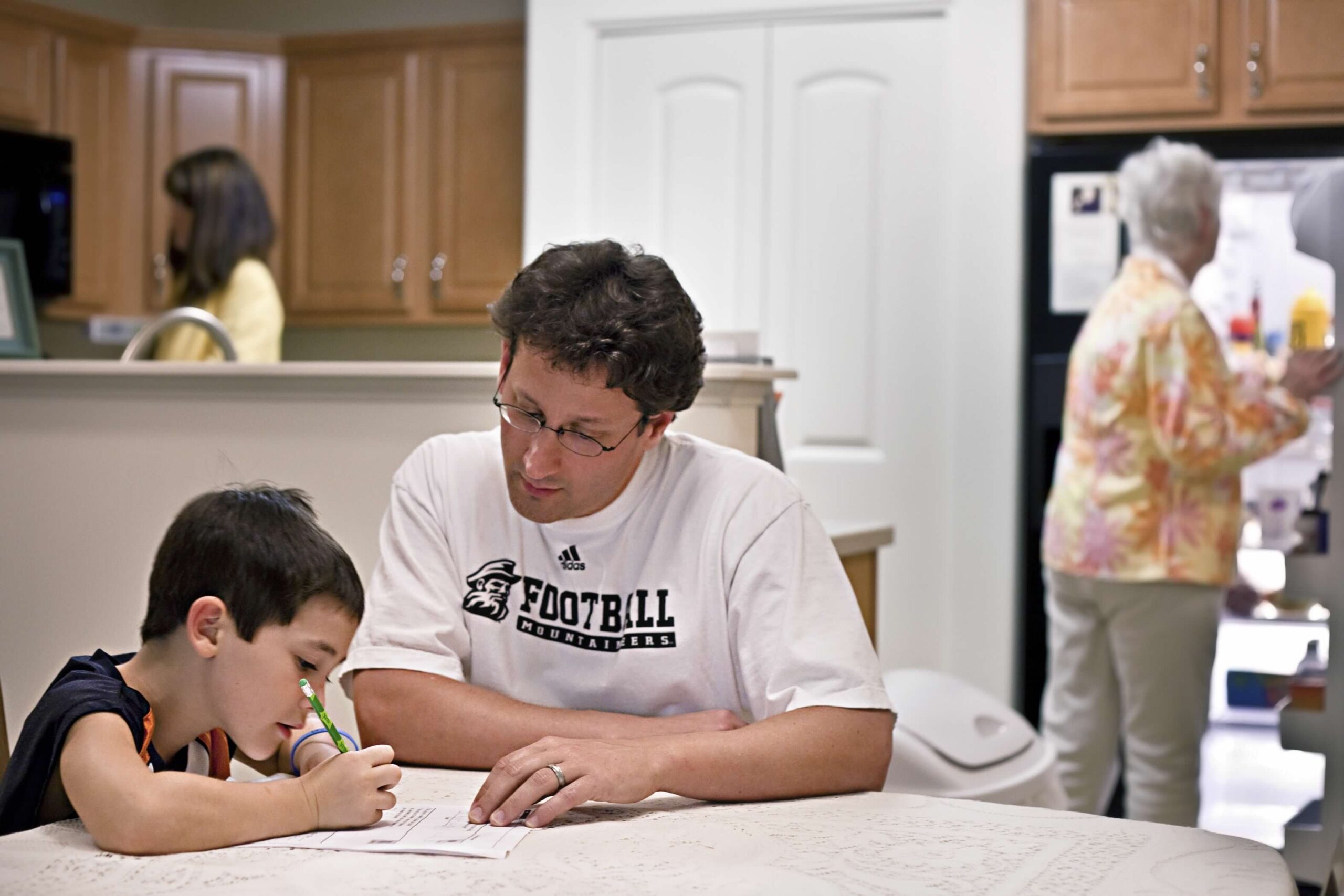 Father and son sitting doing homework at the table